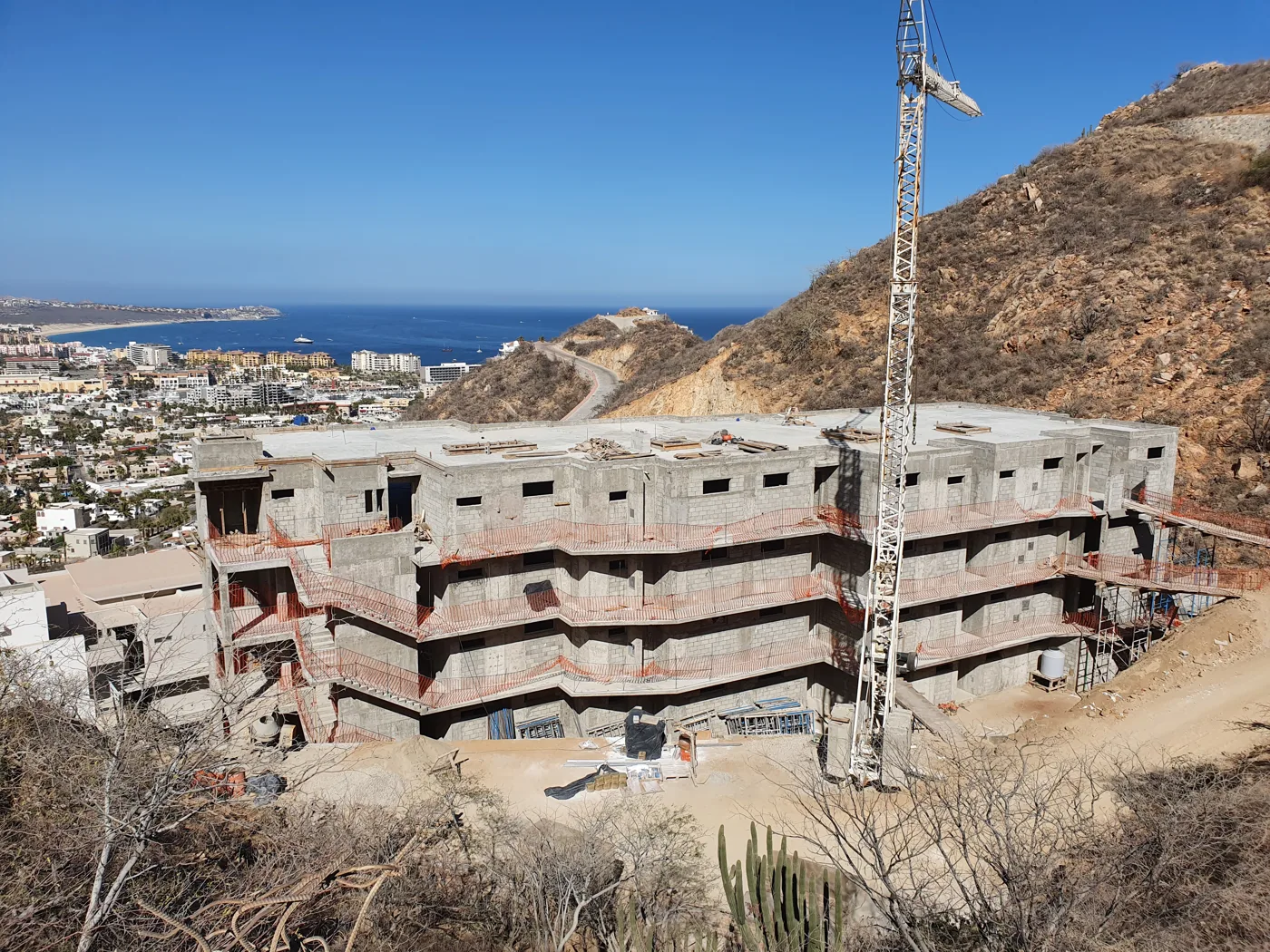Later building structure with a crane and Cabo San Lucas in the background