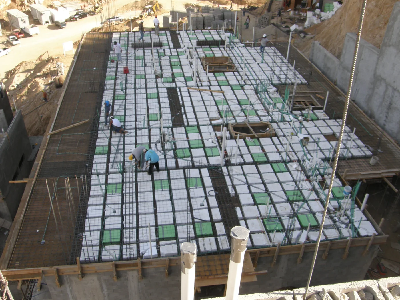 Workers preparing reinforcing steel and floor forms at Las Cascadas